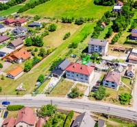 Aerial view of houses in Púchov with surrounding greenery and road infrastructure.