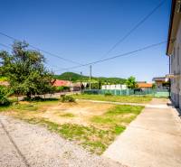 A family house in Púchov, surroundings with a grassy plot and an asphalt road.
