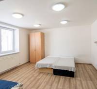Bedroom with a bed, wardrobe, and window in a 2-room apartment.