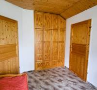 A room in a family house with a built-in wooden wardrobe and doors.