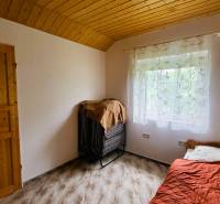 A room with a wooden ceiling and a bed in a family house.