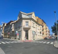 Intersection on Milcova Street in Žilina with commercial spaces and surrounding buildings.