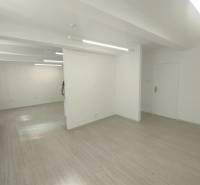 Bright commercial space with white walls and wooden flooring.