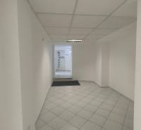 Brightly lit commercial spaces with tiled floors and white walls.