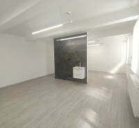 Commercial premises with a sink and a dark wall, equipped with lighting fixtures, underfloor heating.