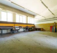 Spacious interior, warehouses and halls, with work tables and storage shelves.
