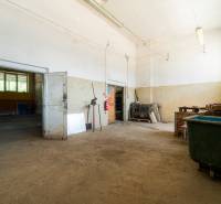 Production premises with old doors, metal tools, and a large waste container.