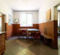 Manufacturing premises with a dining table, chairs, cabinets, and a microwave.