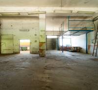 Abandoned industrial spaces with old metal stairs and worn-out flooring.