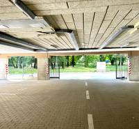 The garage doors are open with a view of the surrounding greenery.