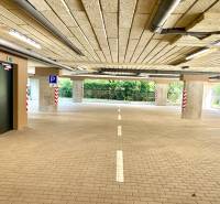 Parking garage with barrier-free access, illuminated and with marked parking spaces.