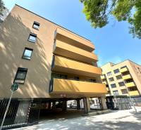 Apartment complex with glass balconies, garages in Senica on Sadová Street.