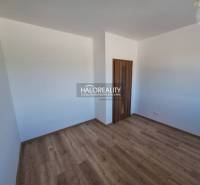 A room with a wooden floor and white walls, part of a 2-room apartment.