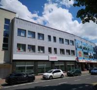 Office building on 1st May Street in Poprad with parked cars.