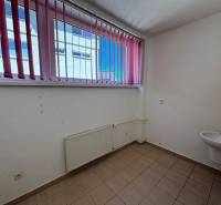 Interior of empty commercial space with window and sink.