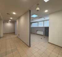 Commercial space with glass doors, tiled flooring, and ceiling lighting.