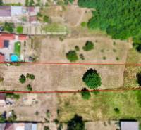 Plots - residential on Mlynská Street in Biel, bordered by a red outline, surrounded by greenery.