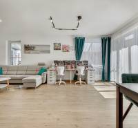 Living room with a sofa and a desk in a family house, bright room with windows.