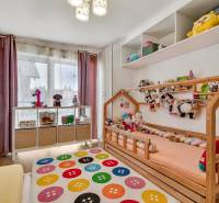 A children's room in a family house with toys and a colorful carpet.
