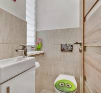 Bathroom in a family house with a toilet and decorative ceramic tiles.