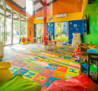 A colorful indoor playground under construction in an apartment building with toys and tables.