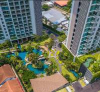 Construction of apartments in the city of Pattaya, with landscaped gardens and swimming pools near residential buildings.