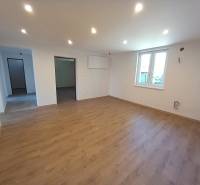Living room in a family house with wooden flooring and white walls.