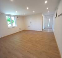 A spacious room with laminate flooring and spotlights in a family house.
