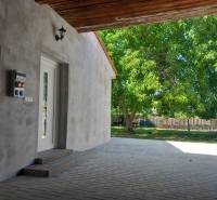 A family house in Trakovice with a paved yard and a large tree on the lawn.