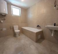 Bathroom in a family house with a bathtub, sink, and toilet.