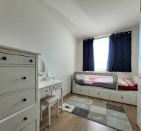 Children's room with a bed, dresser, and carpet in a 3-room apartment.