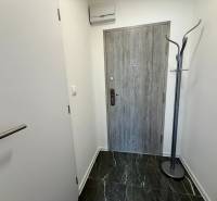 Entrance hall with grey doors and a floor coat rack in a studio apartment.