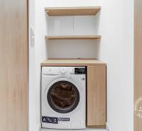 Washing machine with a cabinet and shelves in a 2-room apartment.