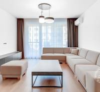 A bright living room with a corner sofa in a two-room apartment, complemented by a coffee table.