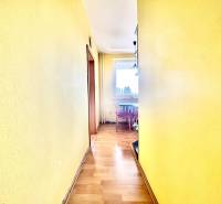 The yellow hallway leads to a bright kitchen in a three-room apartment.