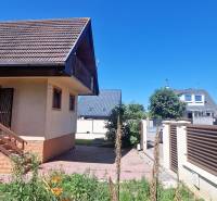 A cottage in Senec with a staircase, terrace, and garden under the blue sky.