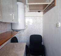 A narrow hallway in the cottage with a boiler and storage spaces, suitable for storage.