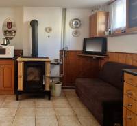 Interior of a cottage with a kitchen, stove, refrigerator, and sofa.