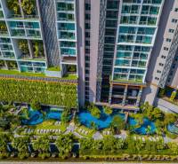 Apartment construction in Pattaya with panoramic views of pools and greenery.