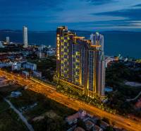 Construction of apartments in the city of Pattaya by the sea, illuminated skyscrapers and city skyline.