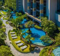 A swimming pool surrounded by greenery and walkways in a residential development in Pattaya.