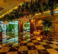 Luxurious interior with a chandelier, green decorations, and patterned flooring. Apartment construction.