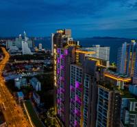 Night panorama of Pattaya with apartment construction by the coast, illuminated high-rise buildings.