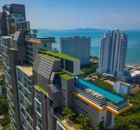 Apartment construction in Pattaya with a rooftop pool and panoramic views of the coastline.