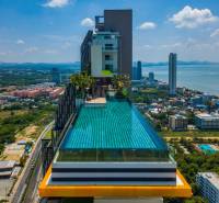 Apartment construction in Pattaya with a rooftop pool and sea view.