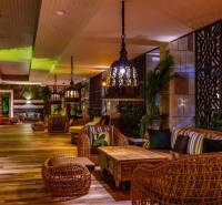 Interior of residential building with comfortable rattan furniture and decorative lighting.
