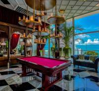 Luxury interior with a pool table, large windows, and an ocean view. Apartment construction.