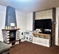 Living room with a sofa, fireplace, and a wall with a television in a 3-room apartment.