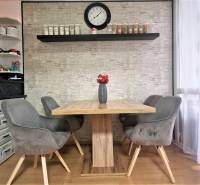 Dining area with a table and gray chairs in a 3-room apartment.