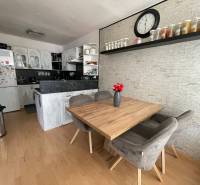 Dining area with kitchen and shelf in a 3-room apartment.